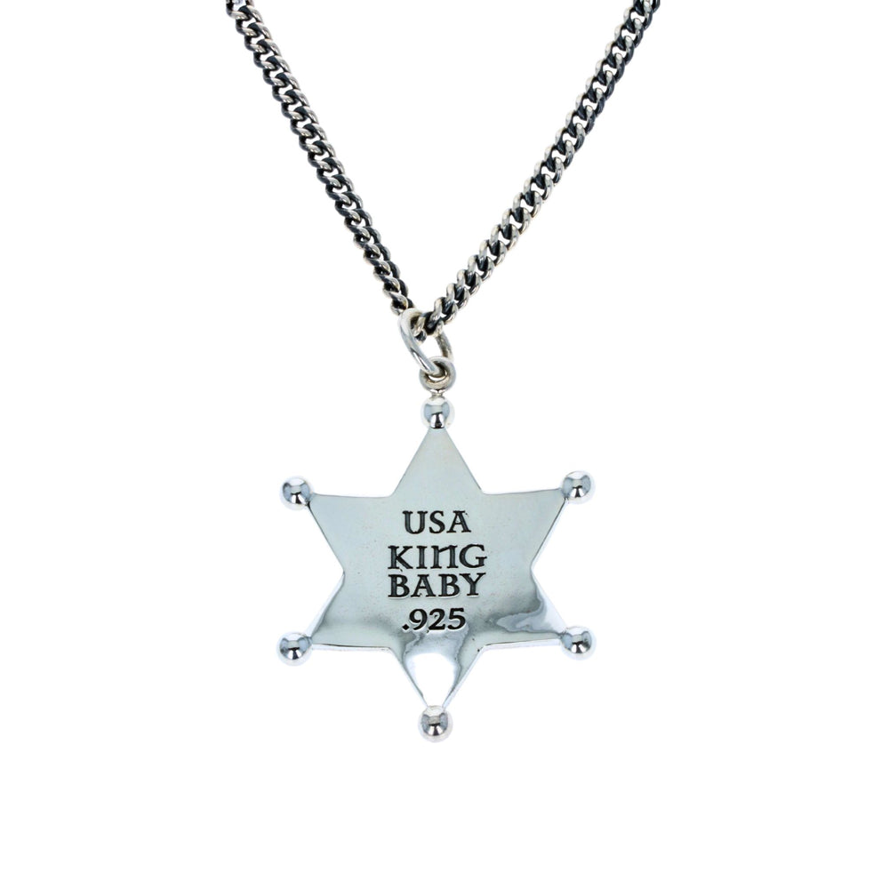 Silver star-shaped pendant with 'USA KING BABY' text on a chain against a white background