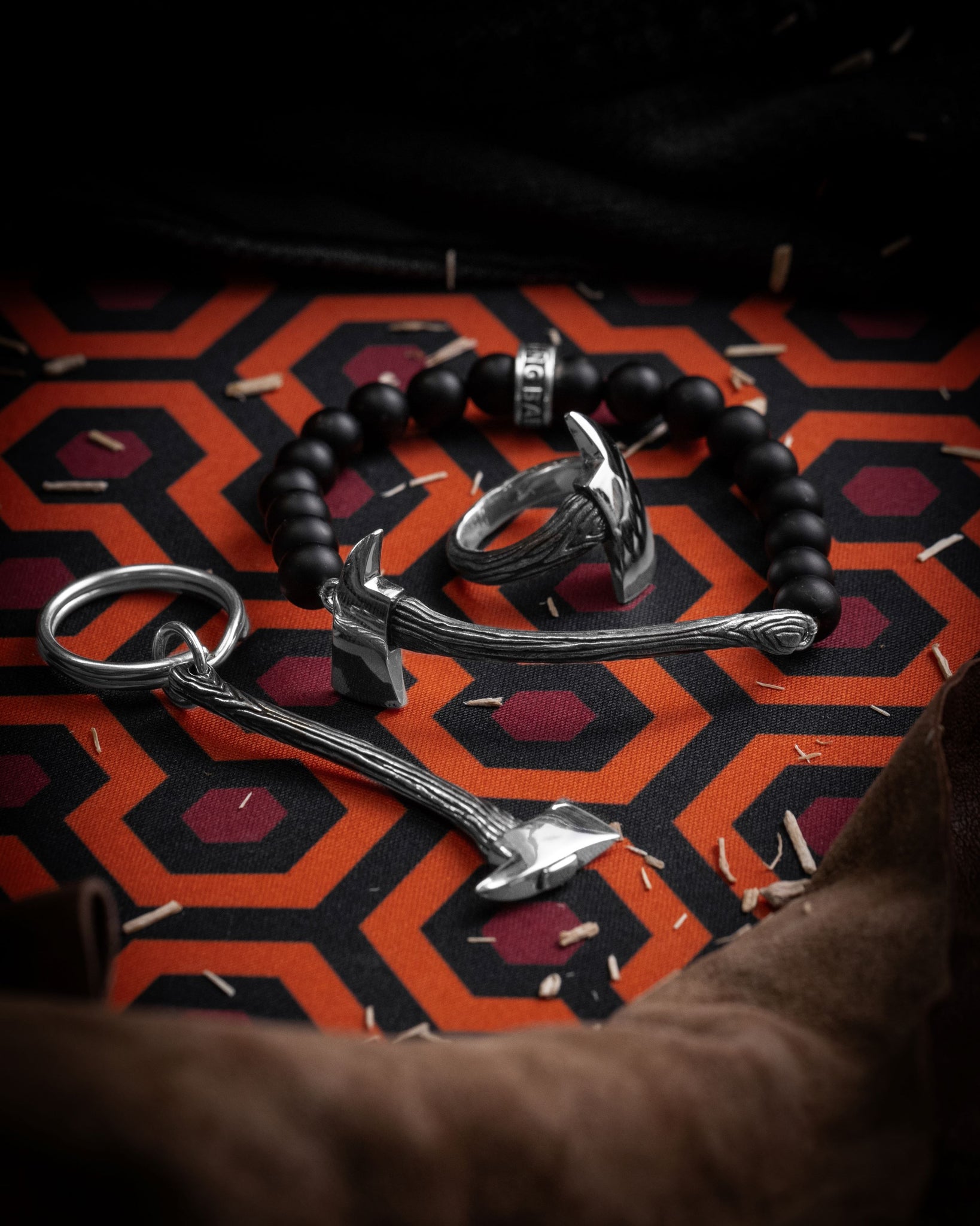Style shot of axe key chain, axe bead bracelet, and wrapped axe ring