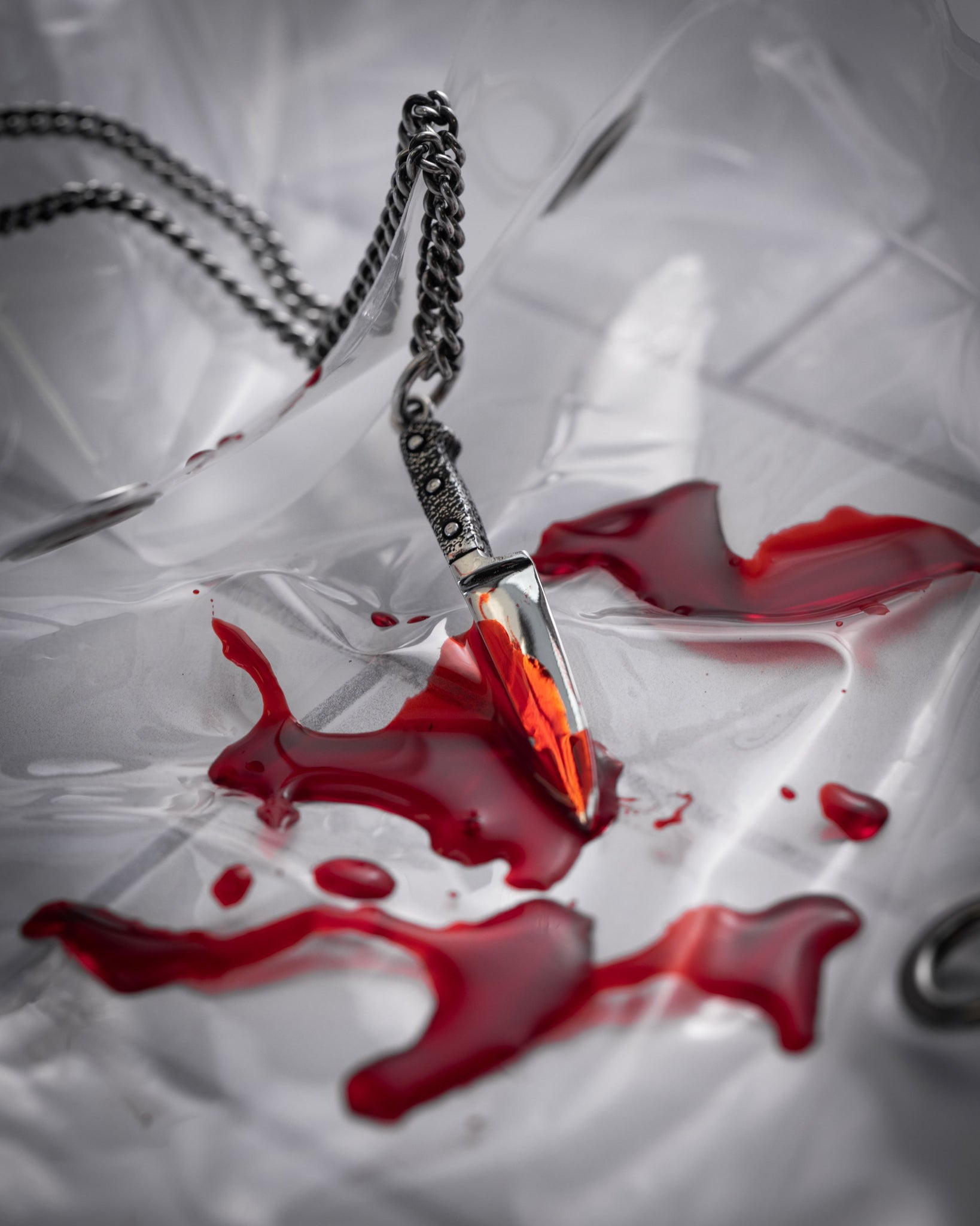 Style shot of kitchen knife pendant in red goo