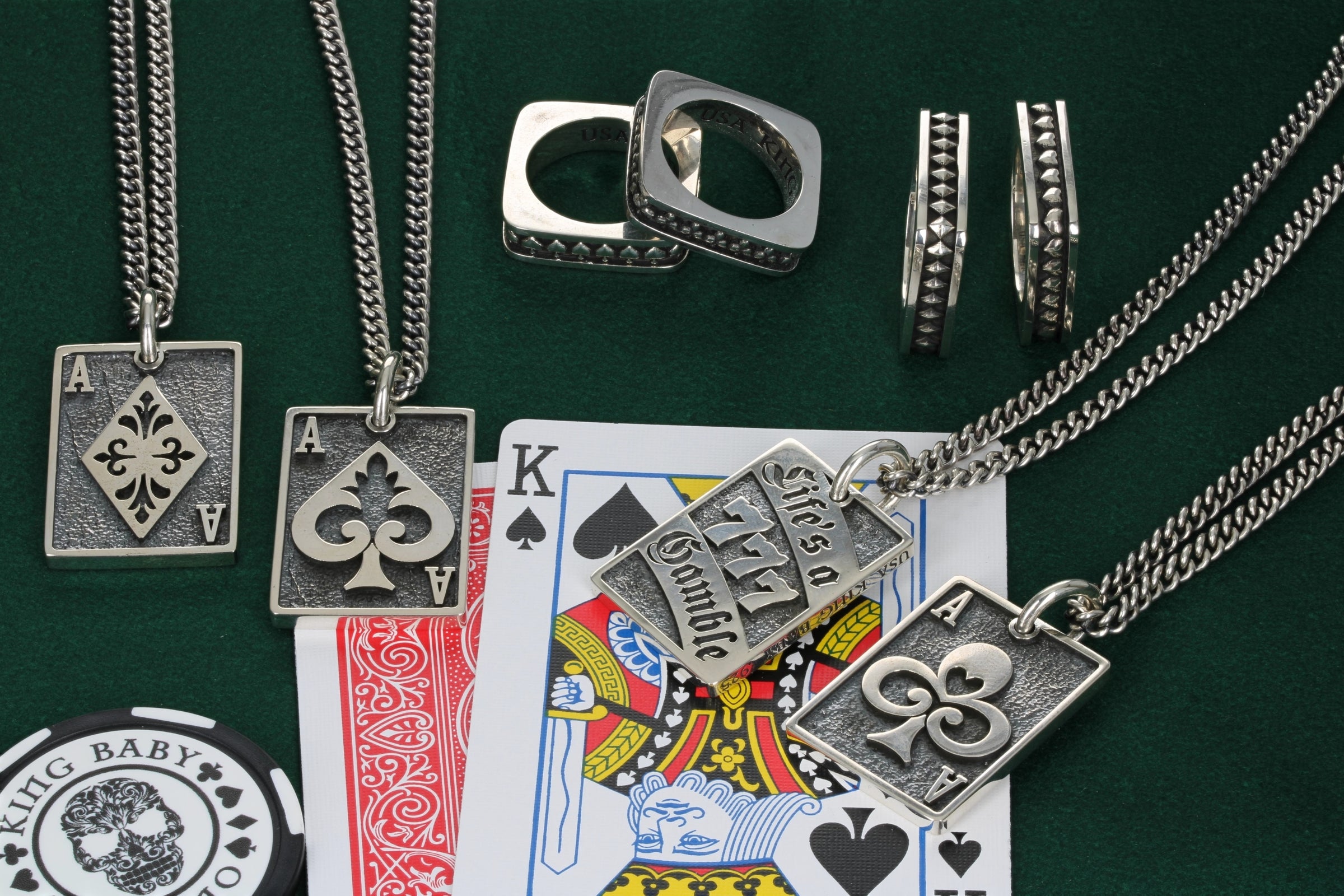 High roller card pendants and suit rings on playing table