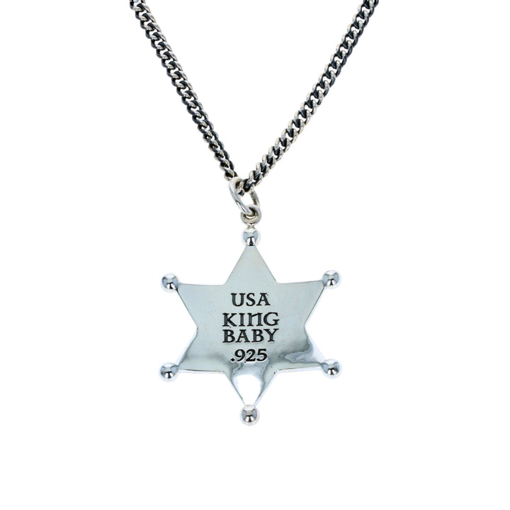 Silver star-shaped pendant with 'USA KING BABY' text on a chain against a white background
