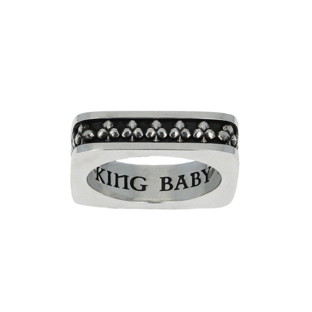 Silver club suit ring with black gemstones and 'USA KING B' engraving on a white background motif close up