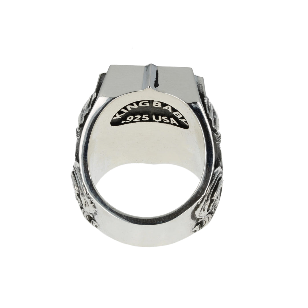 Silver ring with intricate dollar symbol design on a white background back