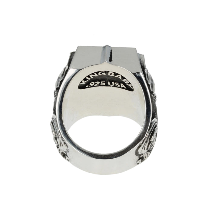 Silver ring with intricate dollar symbol design on a white background back
