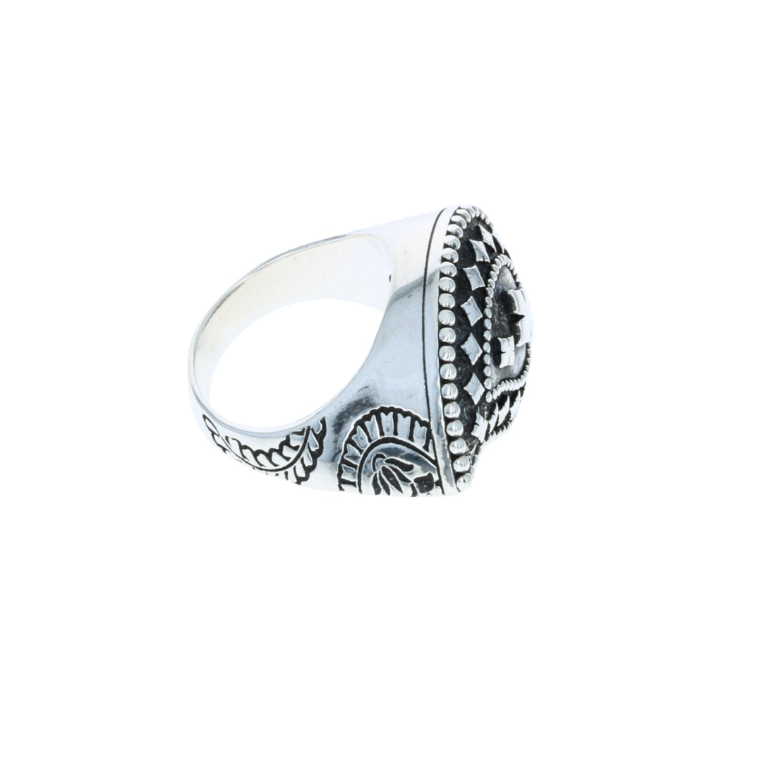 Silver ring with intricate design on a white background