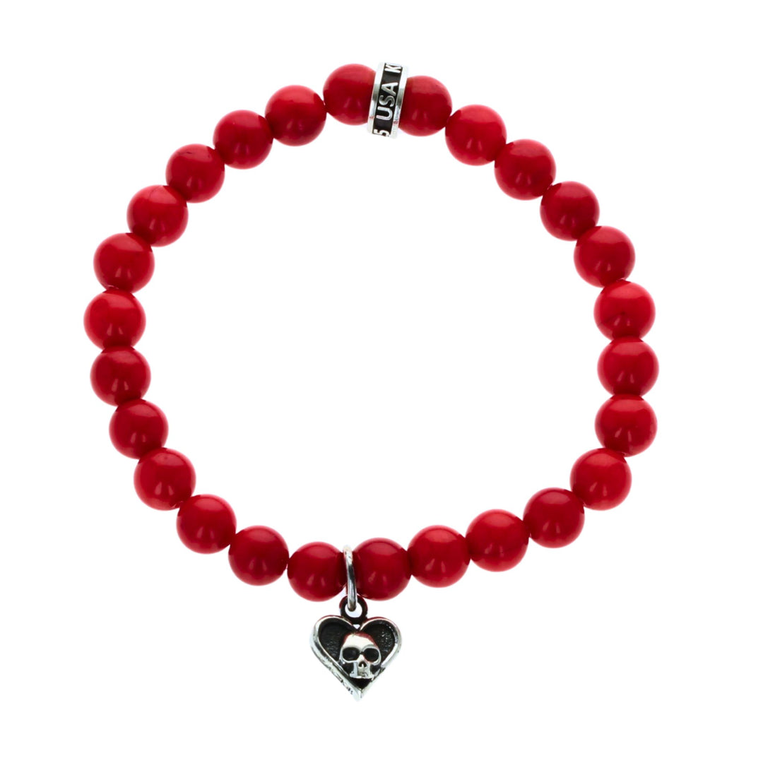 Red beaded bracelet with a heart skull charm on a white background