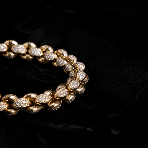 Close up shot of 10k Gold Large Infinity Link Bracelet w/ Pave Diamonds on black background