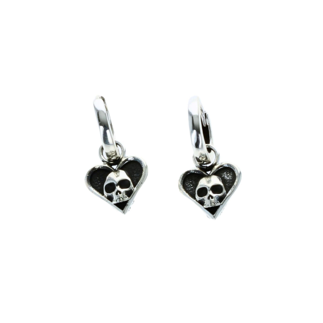 Heart-shaped earrings with skull designs on a white background