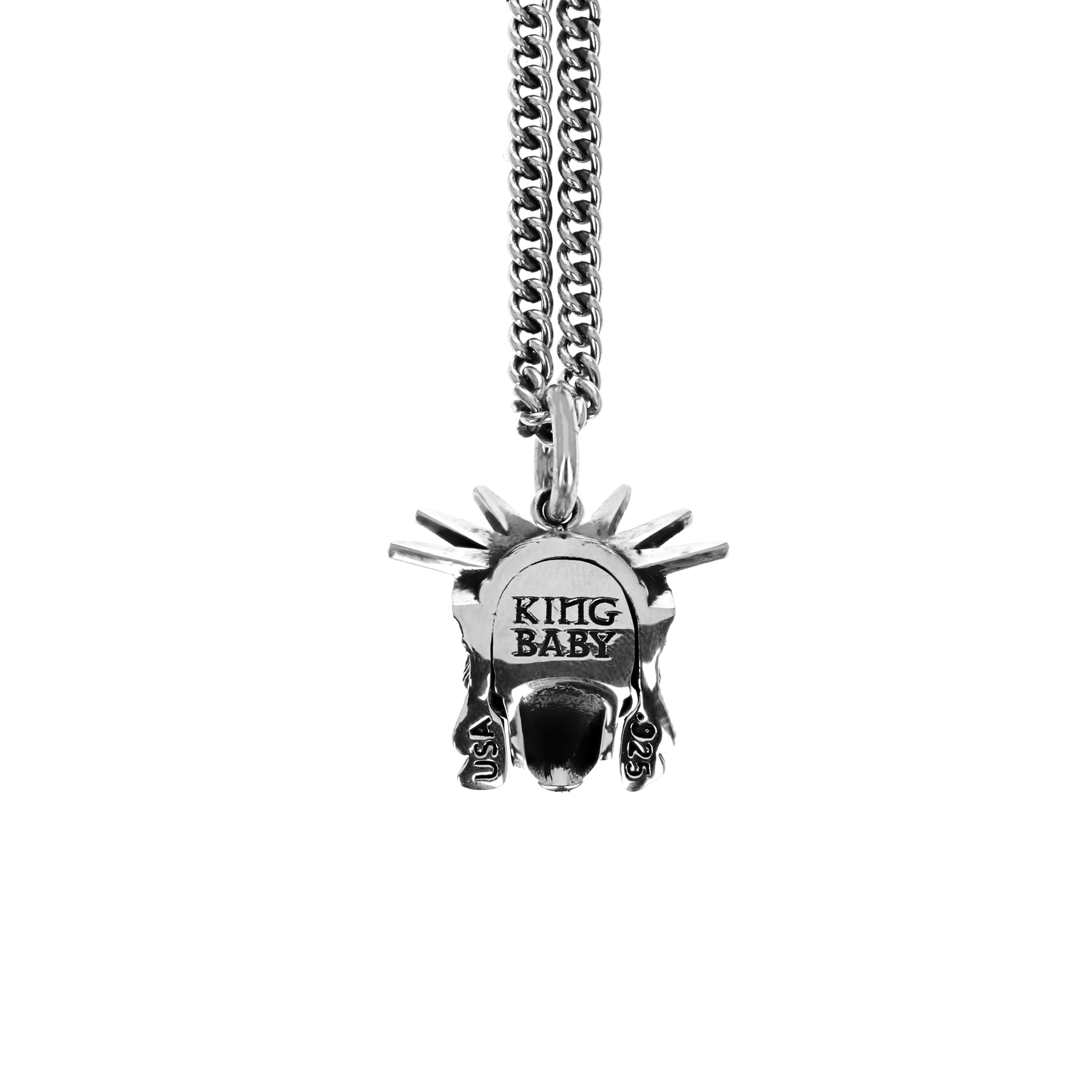 Product shot of back of skull pendant with statue of liberty crown on head