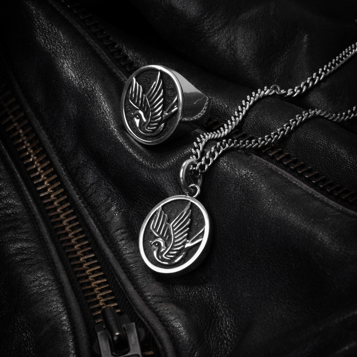 Pendant Sparrow  and ring on black leather background