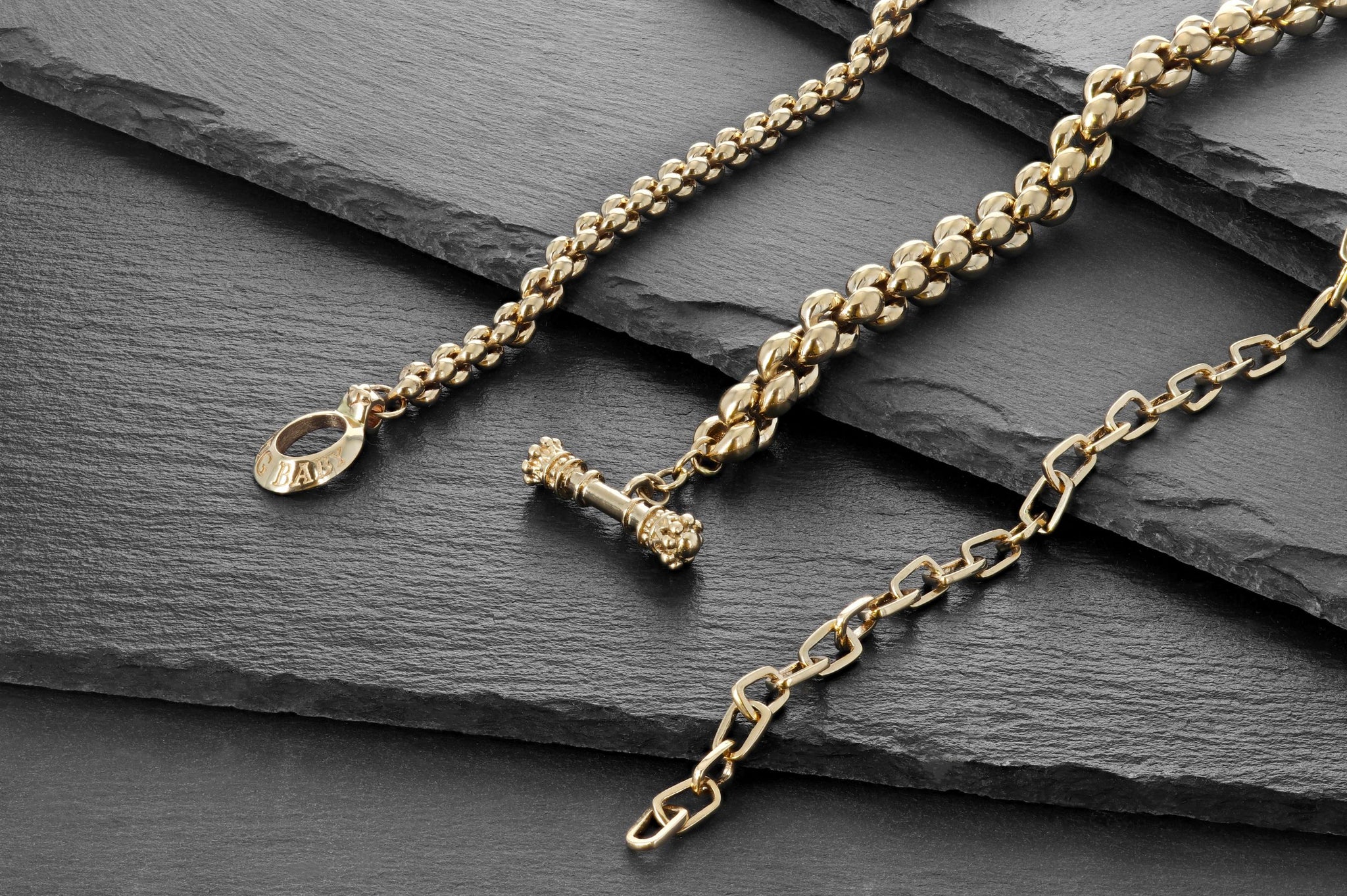 Lifestyle shot of 10k Gold Pop Top Cut Out Bracelet, 10k small infinity link bracelet, 10k large infinity link bracelet.