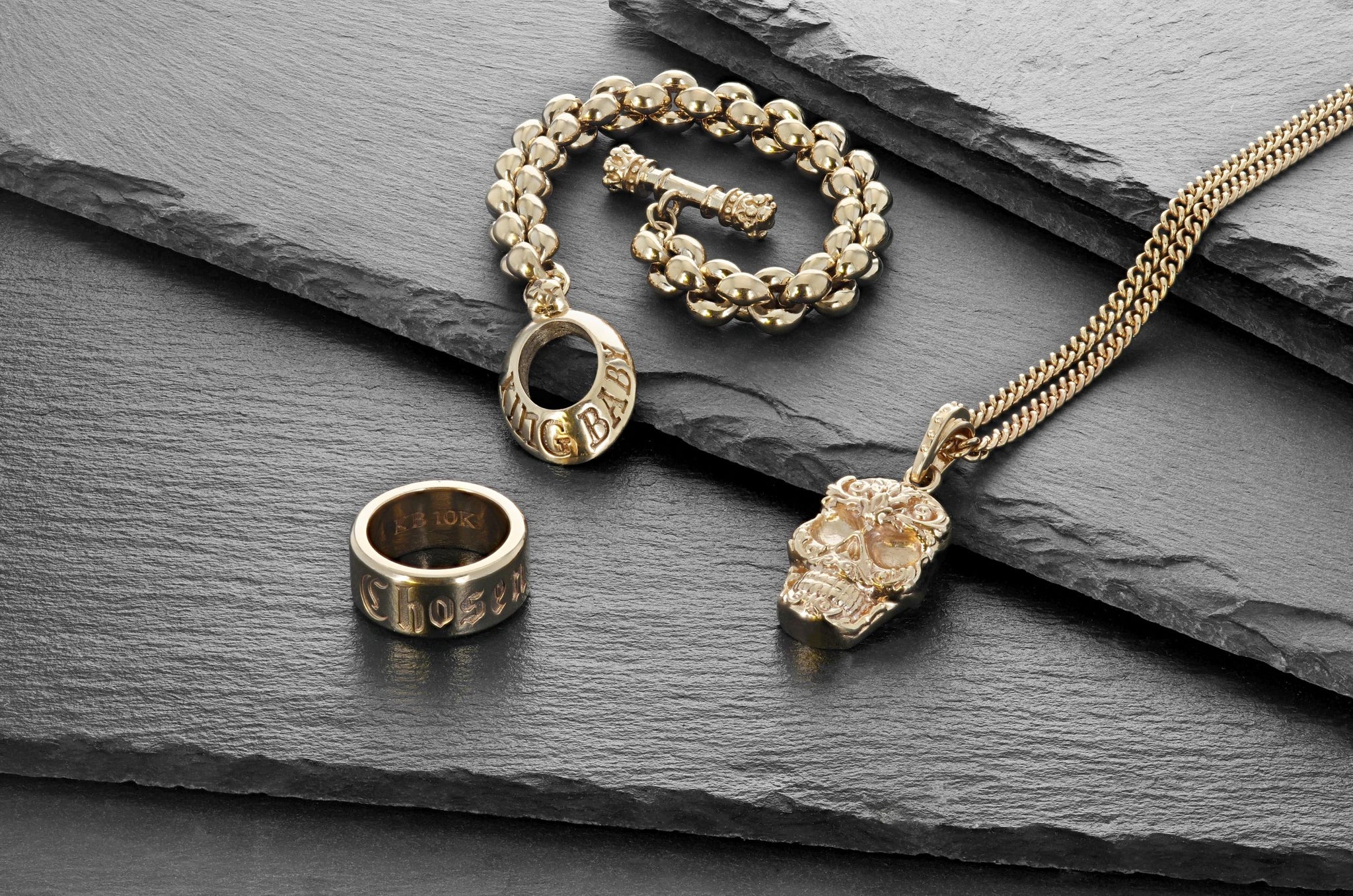 Lifestyle shot of 10K Gold Carved Baroque Skull Pendant with Chosen Ring and Infinity Link Bracelet