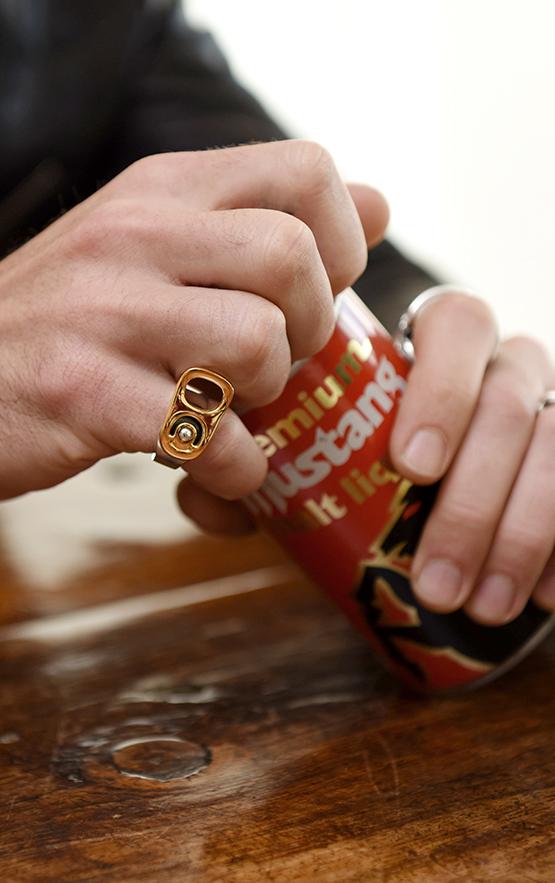man wearing sterling silver jewelry opening a beer