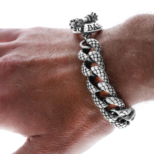 Close up of snake link textured bracelet on model's hand.